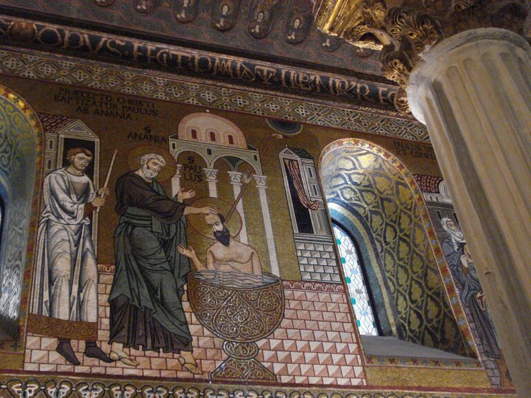 Mosaic of Jesus's baptism: John pours water over Jesus in a decorative church wall scene with bystanders and patterned tile floor.