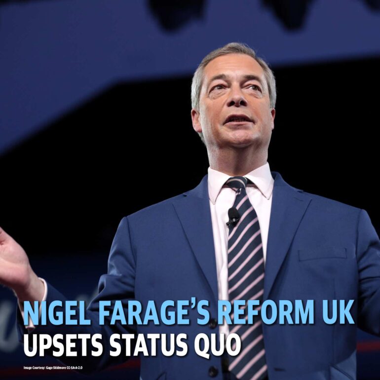 Nigel Farage on stage in a blue suit and striped tie, speaking with a lapel microphone; bold headline text overlays the image.